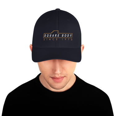 man wearing a square body sice 1973 hat from aggressive thread in navy